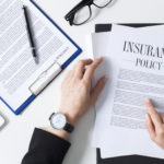 Business woman showing insurance document over white desk at office