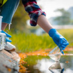 Hands of scientists collecting water samples for analysis and research on water quality.