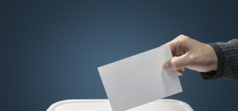 Man putting a ballot paper envelope into a voting box concept for election, freedom and democracy