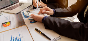 Businessman, accounting, calculating, analyzing, charting and graphing income with a modern laptop computer. And strategy ideas